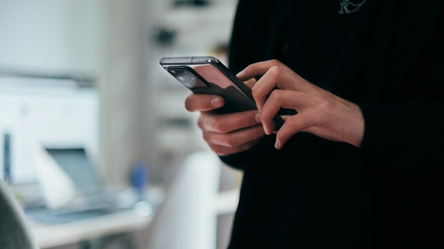 Smart TV Botnet Discovery: What Shoppers Need to Know About Infected Apps 1 person checking smartphone home security
