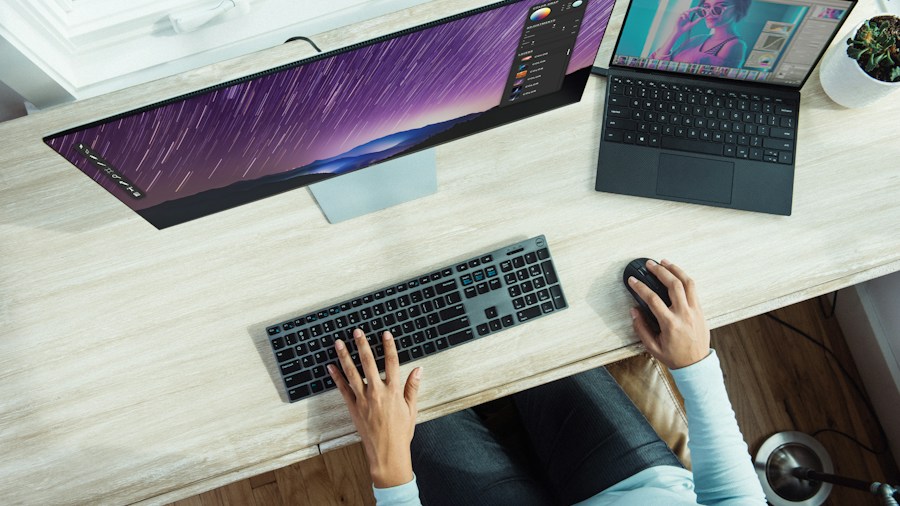 person typing and using mouse desk workspace
